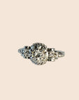 Bague ancienne en or blanc 18 carats ornée d’un diamant taille brillant d’environ 0,1 carat, monture à volutes et torsades inspirée de l’Art Déco, bijou élégant des années 1950.