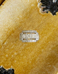 Bague moderniste des années 1950 en or blanc 18 carats et diamants, présenté sur un fond jaune.