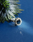 Bague marguerite en or blanc 18 carats sertie d'un saphir naturel ovale entouré de 12 diamants,, photo artistique.