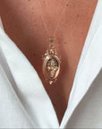 Médaillon porte-souvenir ancien en or rose 18 carats orné d’une croix perlée, porté comme bijou sentimental