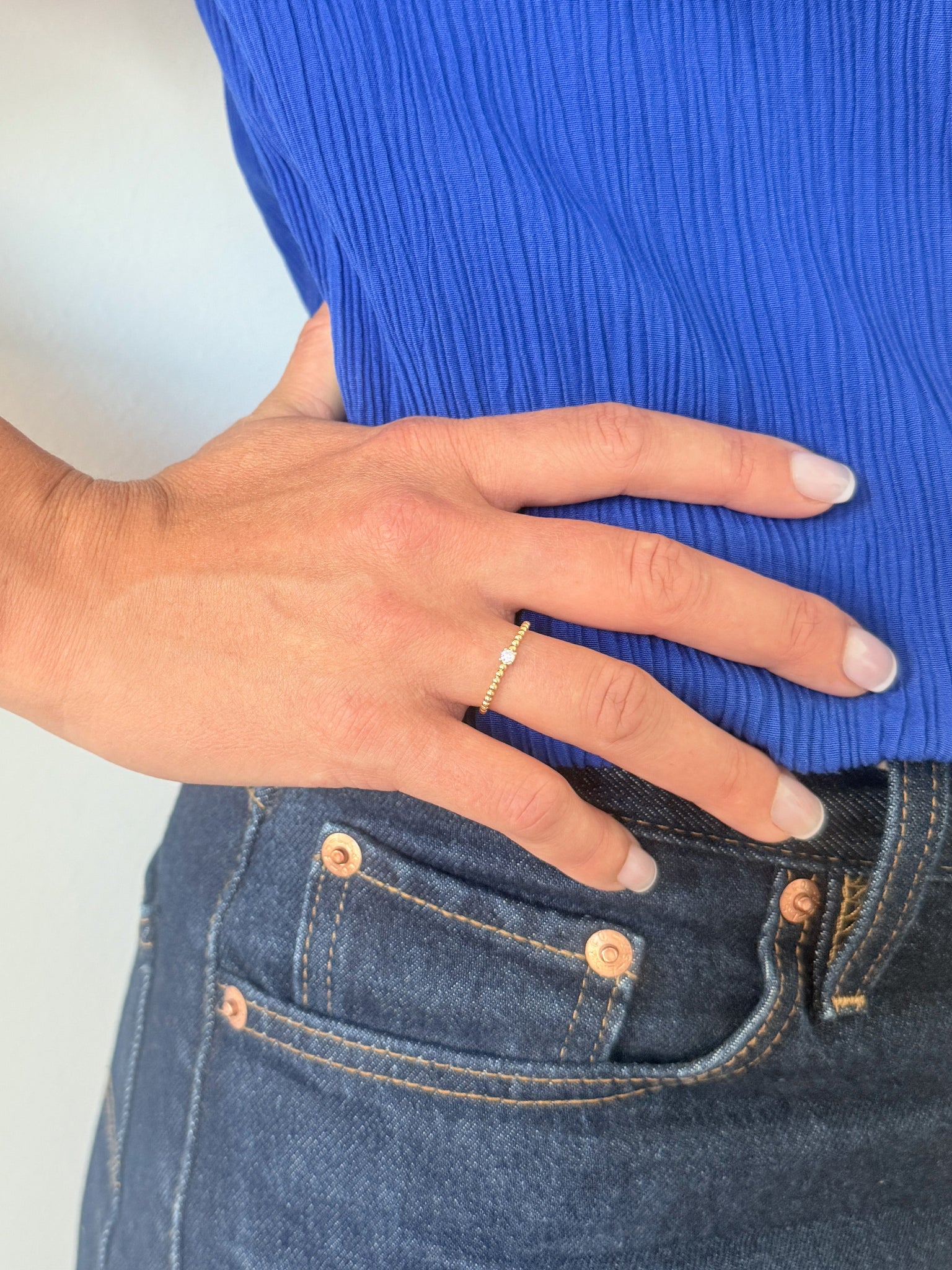 Bague solitaire en or jaune 18 carats ornée d’un diamant en serti griffe sur un anneau perlé, bijou raffiné symbolisant l’unicité et l’élégance intemporelle.