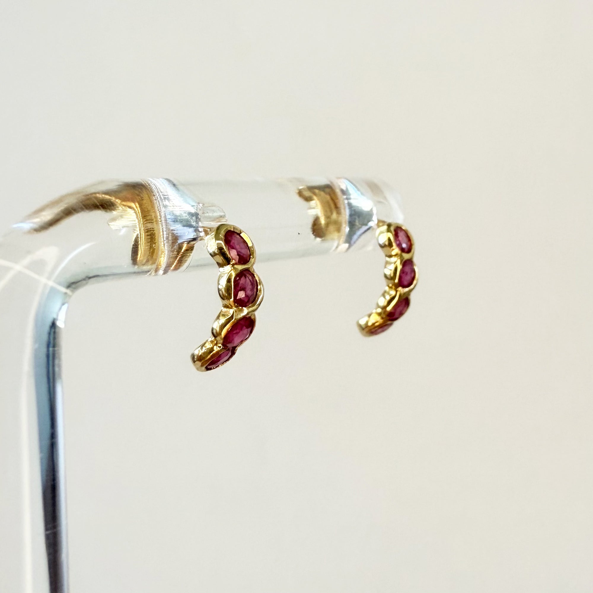 Paire de boucles d’oreilles en or jaune 18 carats ornées de quatre rubis ronds en serti clos, bijoux élégants et colorés.