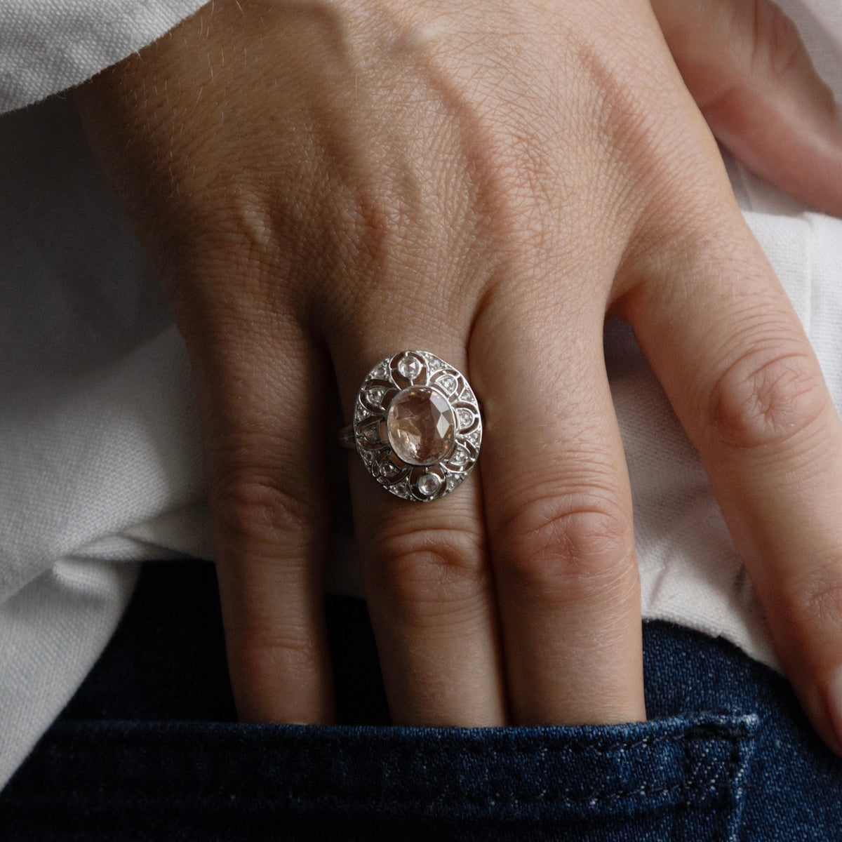 Bague Art déco Maison Labrune avec marguerite en saphir rose naturel et diamants, or 18 carats, portée au doigt.