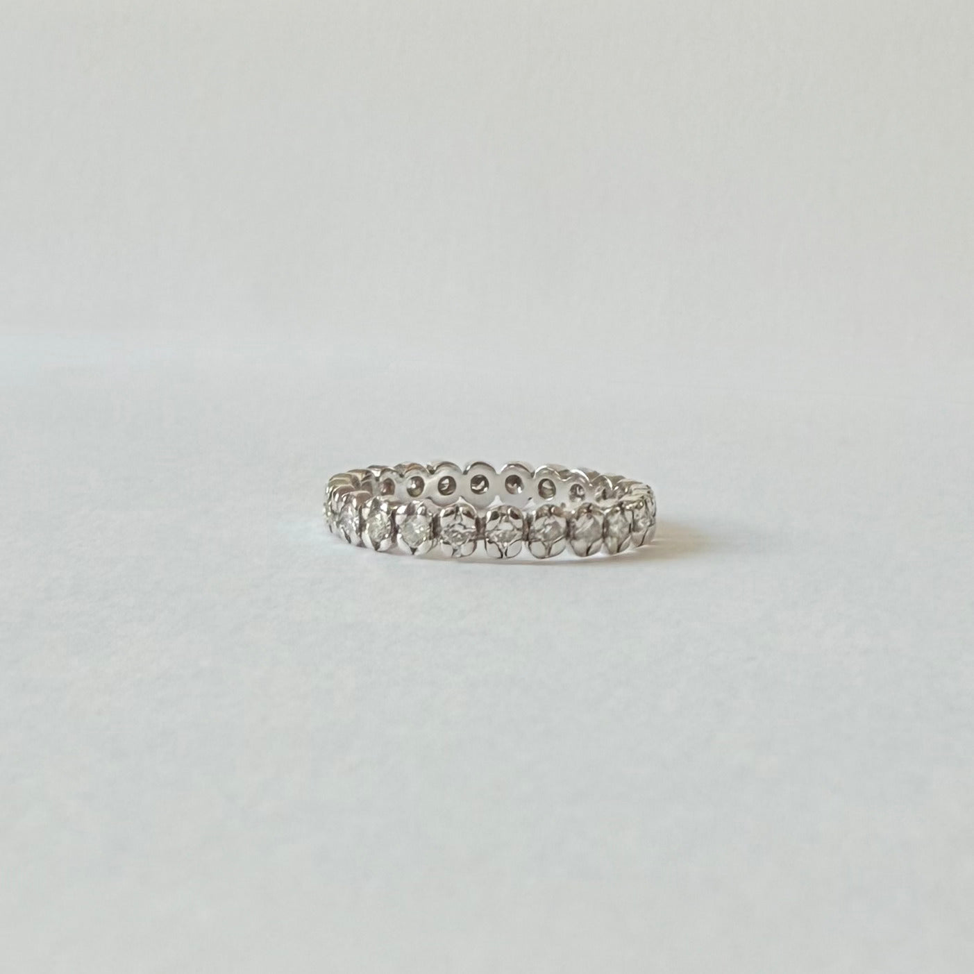 Vue de profil de l'alliance américaine en or blanc 18 carats et de son rang complet de diamants.