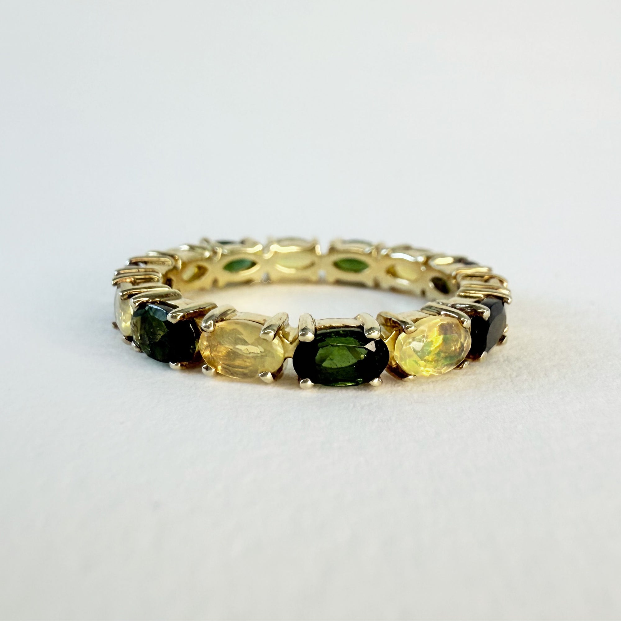 Alliance américaine en vermeil sertie d’opales jaunes et de tourmalines vertes ovales en serti griffe, bijou coloré et moderne alliant élégance et originalité.