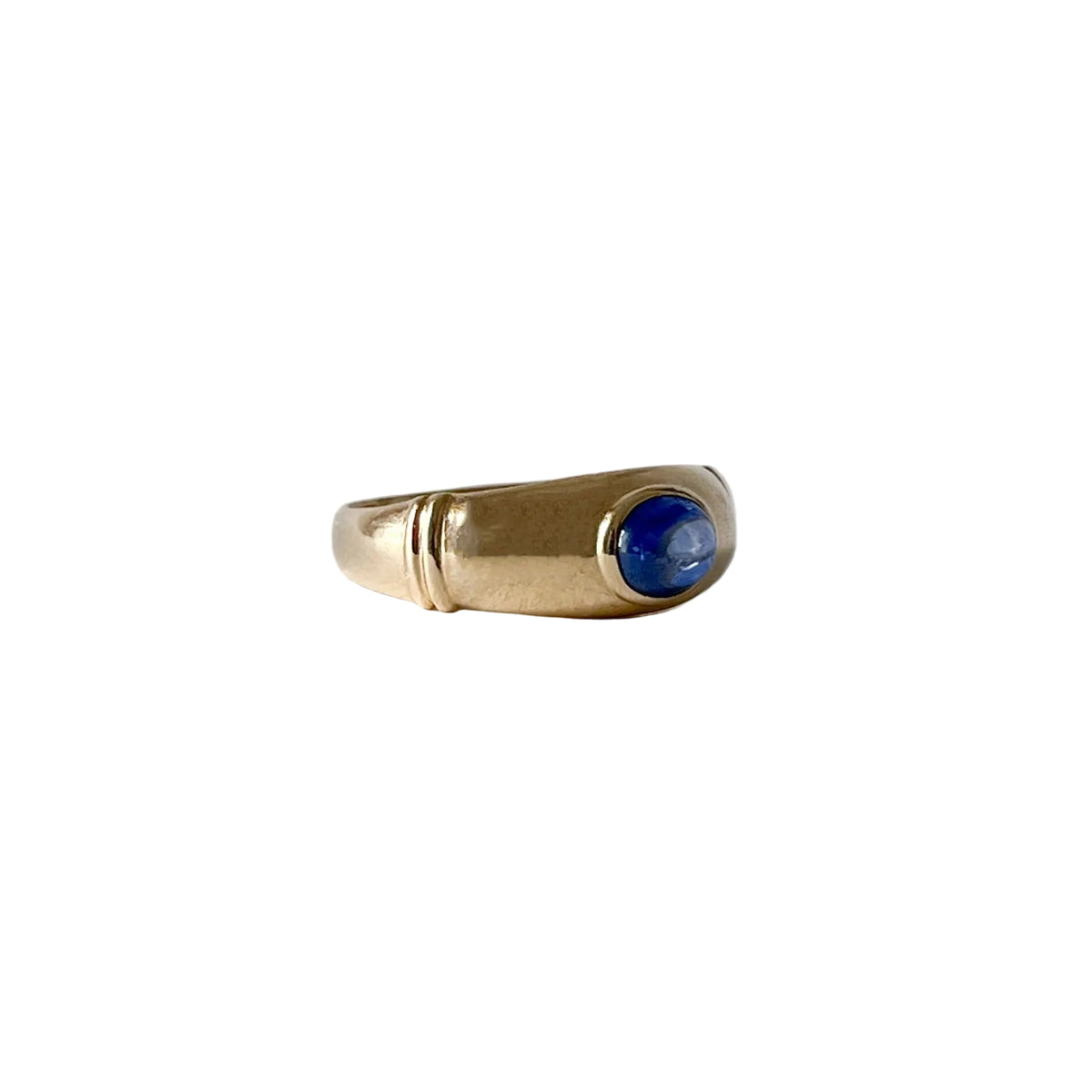 Vue de profil d’une bague en or jaune 18 carats avec saphir cabochon en serti clos