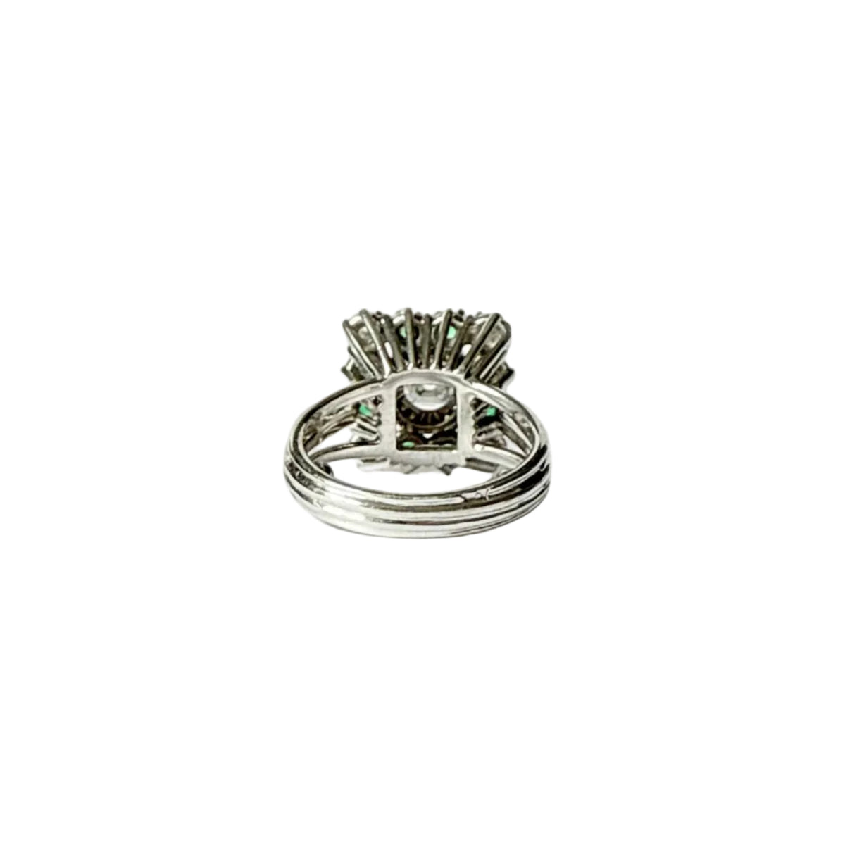 Bague marguerite en or gris 18 carats sertie d'un diamant taille émeraude entouré d'émeraudes et de diamants, vue de l'interieur.