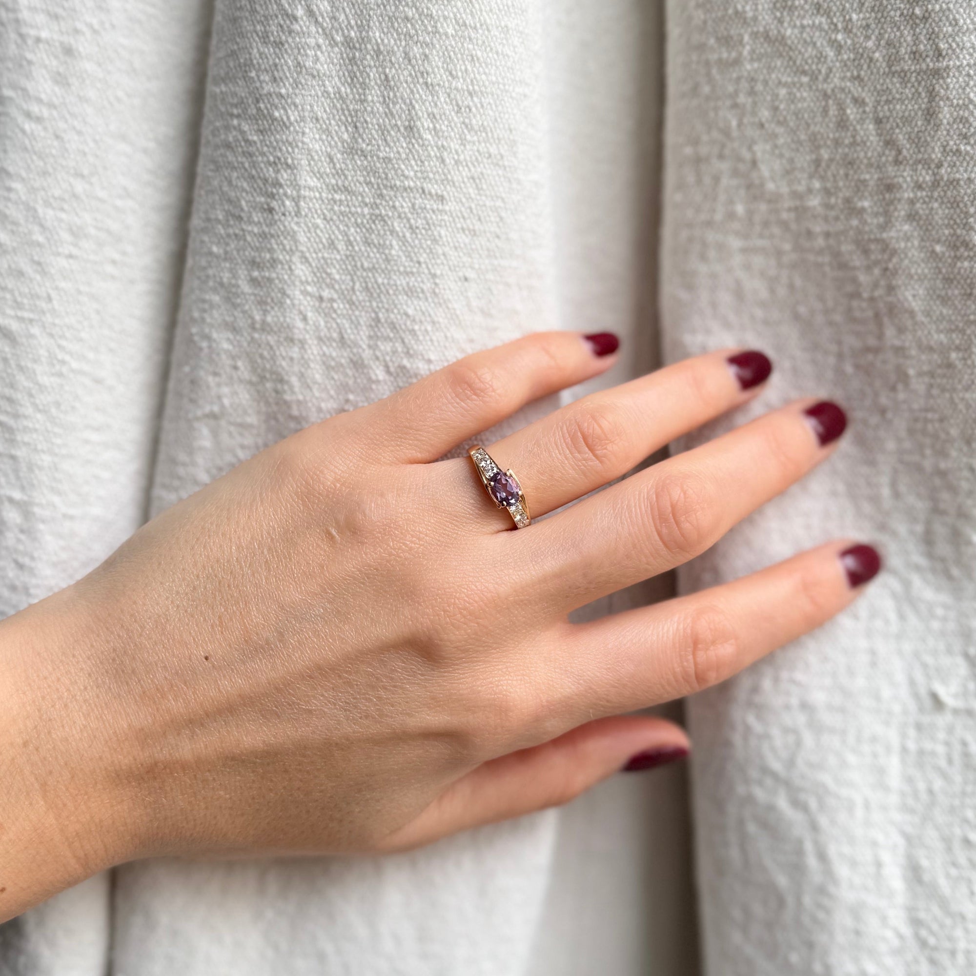 Bague en or jaune sertie d'une améthyste et de diamants, montrée portée. 