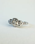 Bague ancienne en or blanc 18 carats ornée d’un diamant taille brillant d’environ 0,1 carat, monture à volutes et torsades inspirée de l’Art Déco, bijou élégant des années 1950.