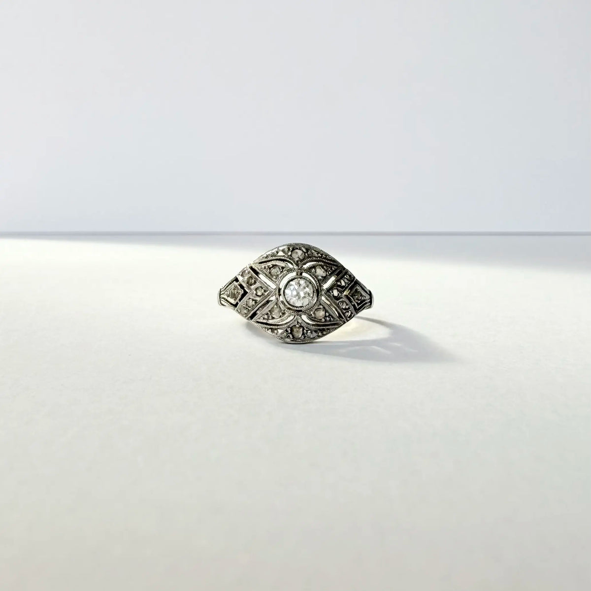 Bague ancienne Art déco en or blanc et diamants, monture en dentelle géométrique. 