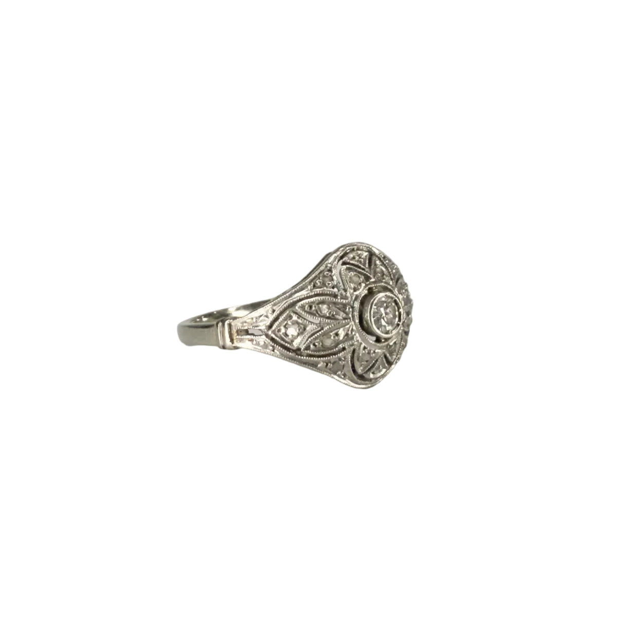 Bague Art Déco en platine ajouré ornée d’un diamant central d’environ 0,1 carat, bijou ancien géométrique de qualité, pièce de joaillerie d’occasion élégante et raffinée.