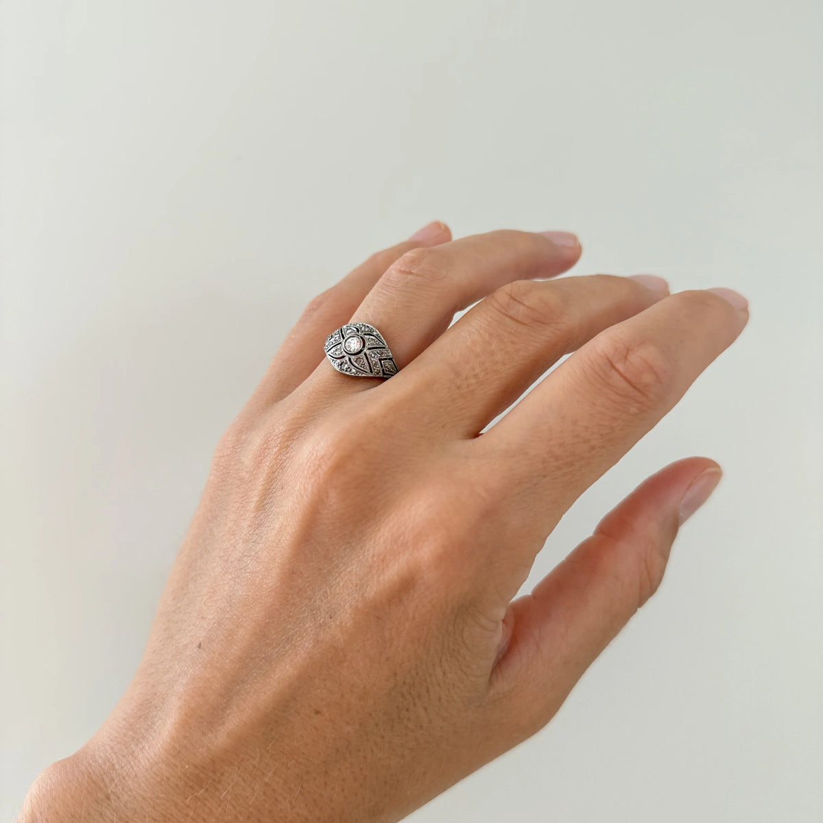 Bague Art déco en or blanc et diamants montré sur un doigt 