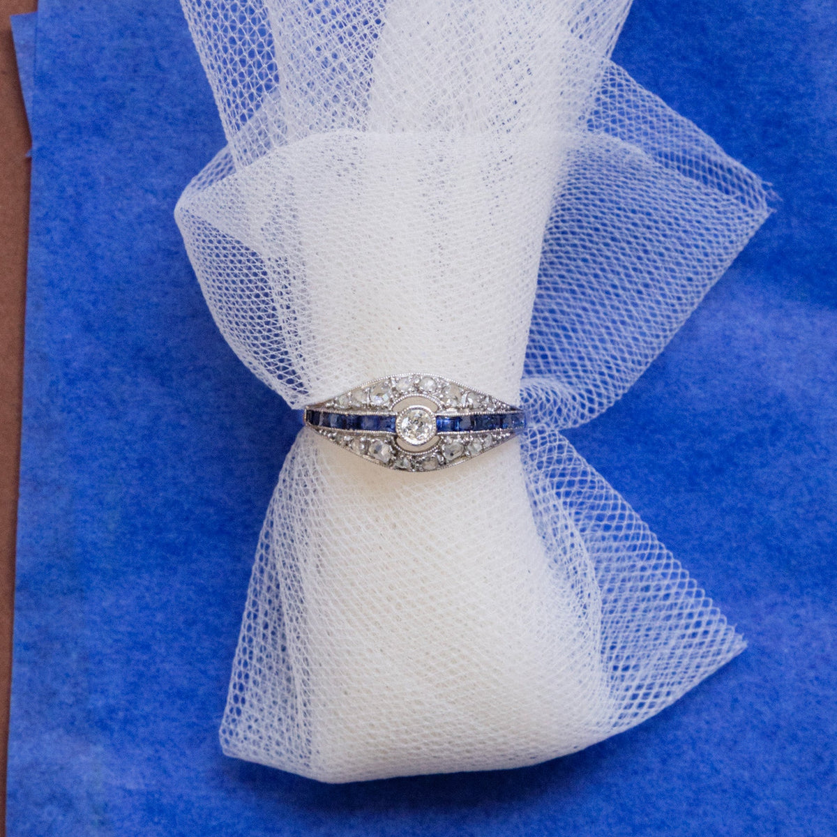 Bague Art Déco ancienne en or blanc 18 carats, ornée d’un diamant central, de diamants taille rose et de saphirs bleus calibrés, années 1920-1930.
