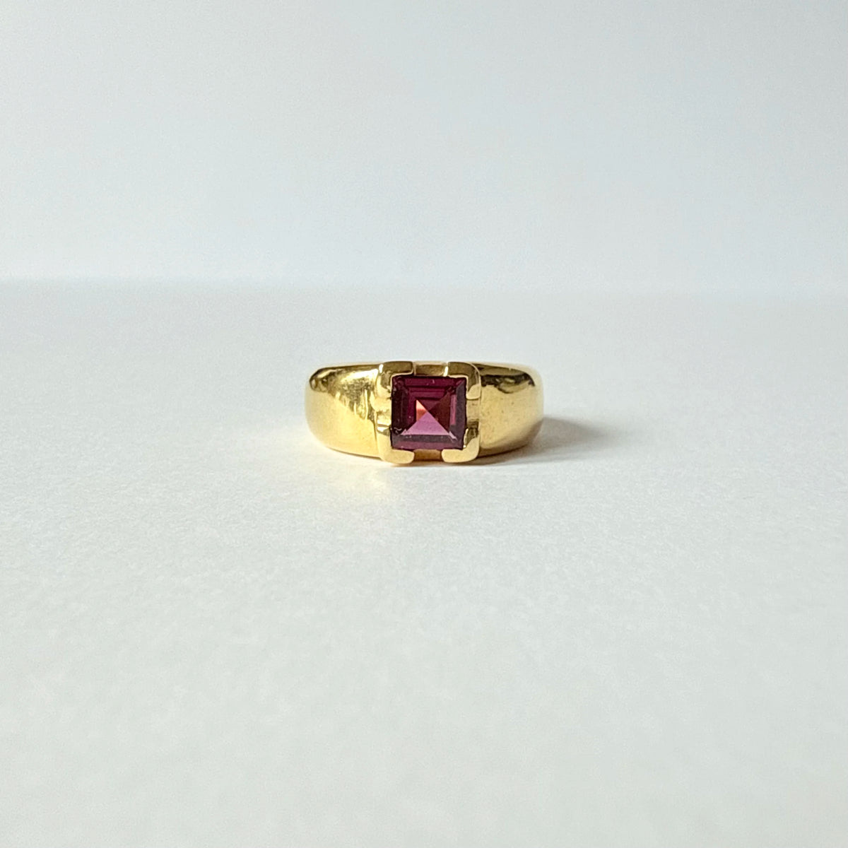 Bague bandeau de style chevalière en or jaune 18 carat ornée d'une tourmaline carré rouge-violet.