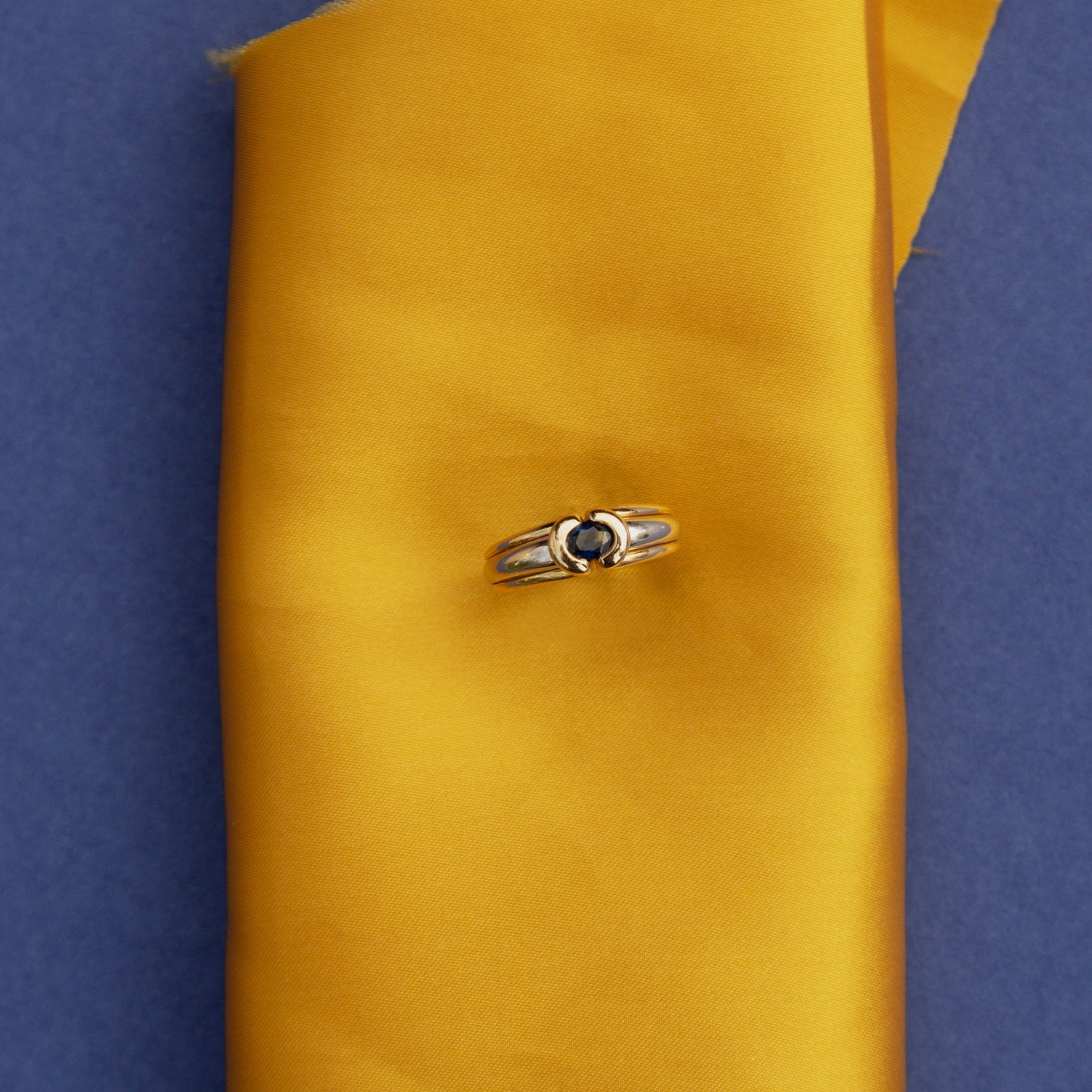 Bague jonc en or jaune et or blanc 18 carats sertie d’un saphir ovale bleu profond