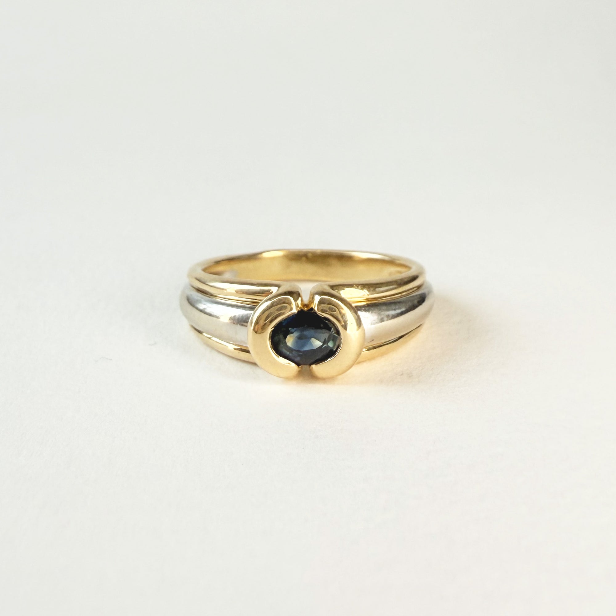 Bague jonc en or blanc et jaune 18 carats avec saphir ovale bleu. Un bijou élégant, intemporel et raffiné pour femme.