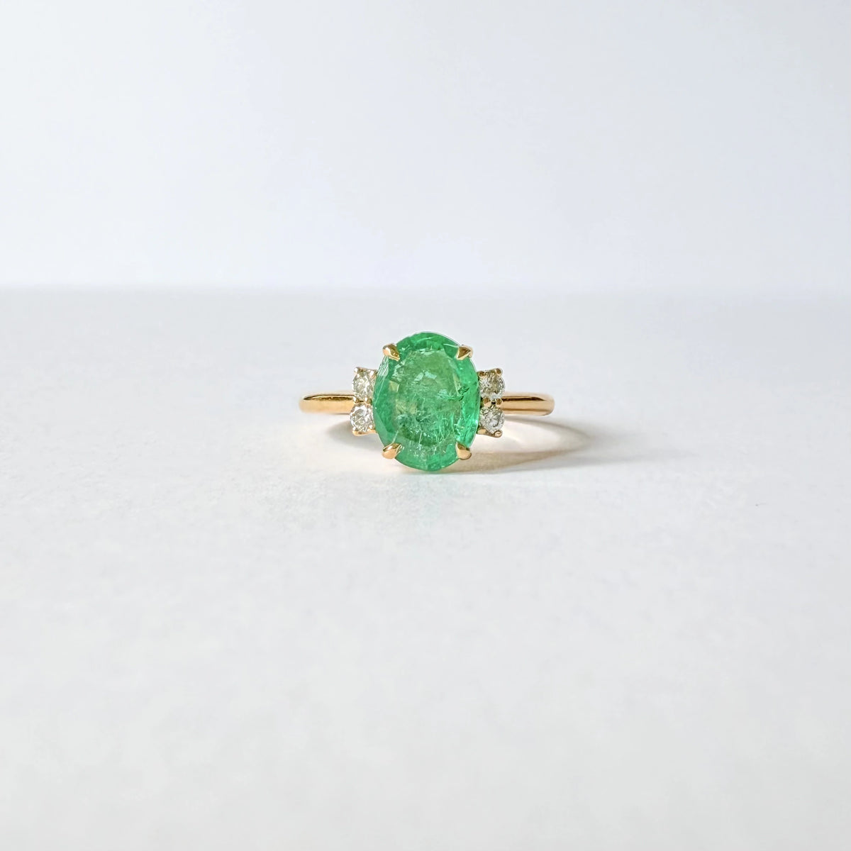 Bague émeraude ovale et quatre diamants sur une monture en or jaune 18 carats