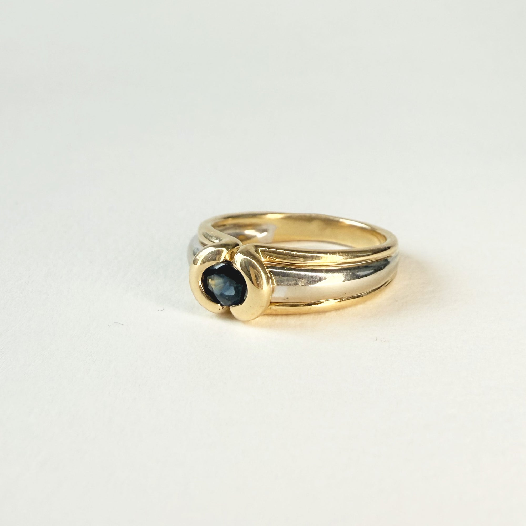 Bague jonc en or blanc et jaune 18 carats avec saphir ovale bleu. Un bijou élégant, intemporel et raffiné pour femme.