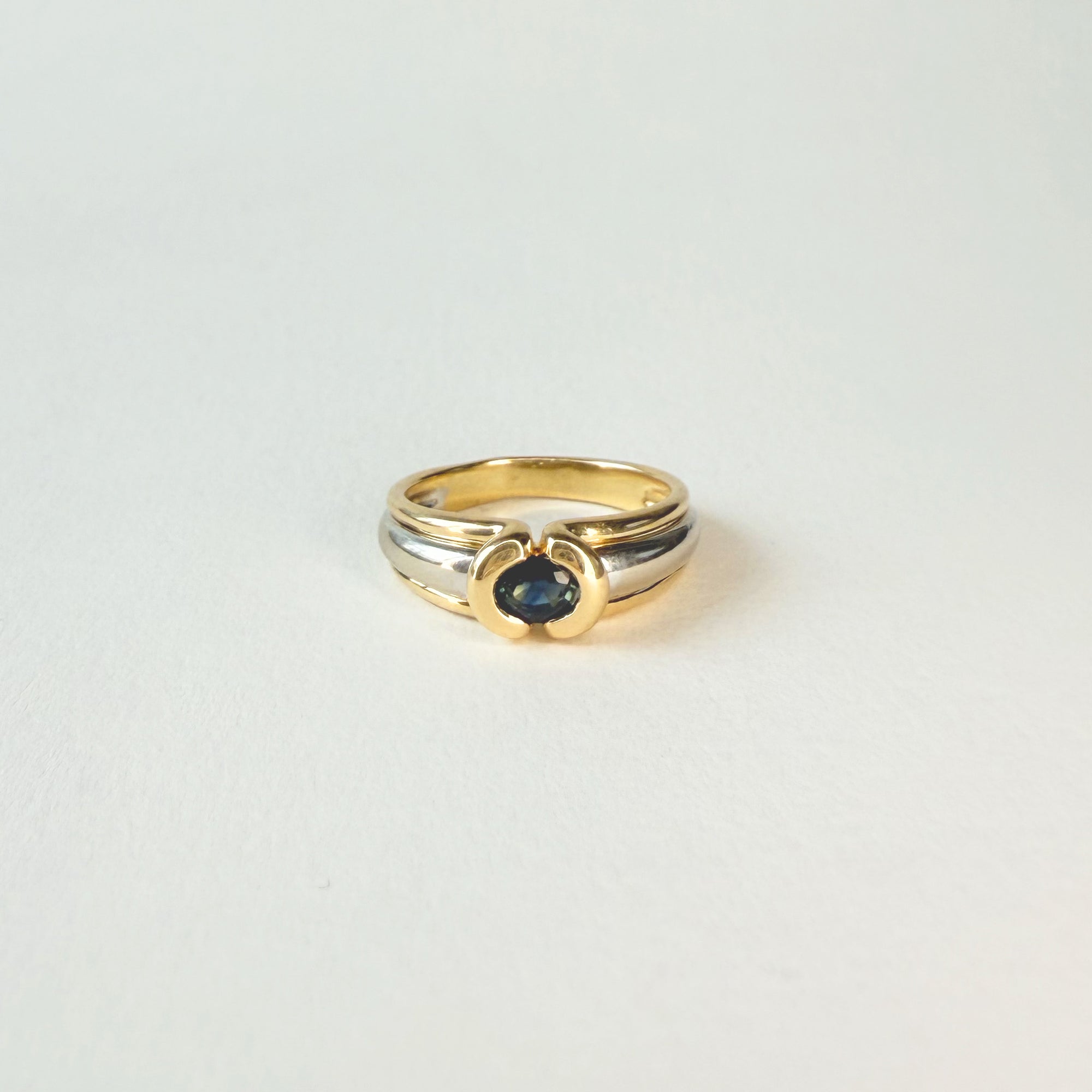 Bague jonc en or blanc et jaune 18 carats avec saphir ovale bleu. Un bijou élégant, intemporel et raffiné pour femme.
