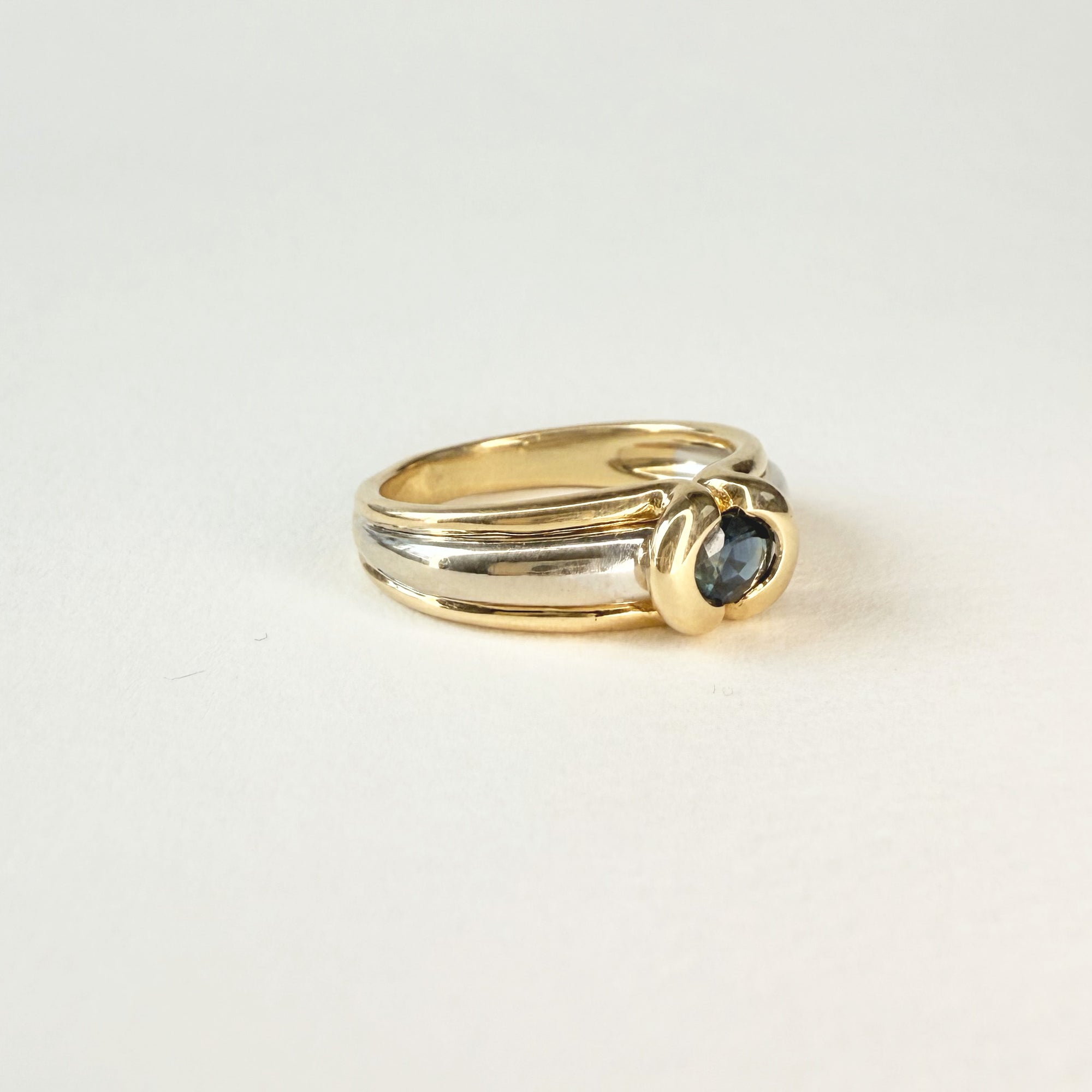 Bague jonc en or blanc et jaune 18 carats avec saphir ovale bleu. Un bijou élégant, intemporel et raffiné pour femme.