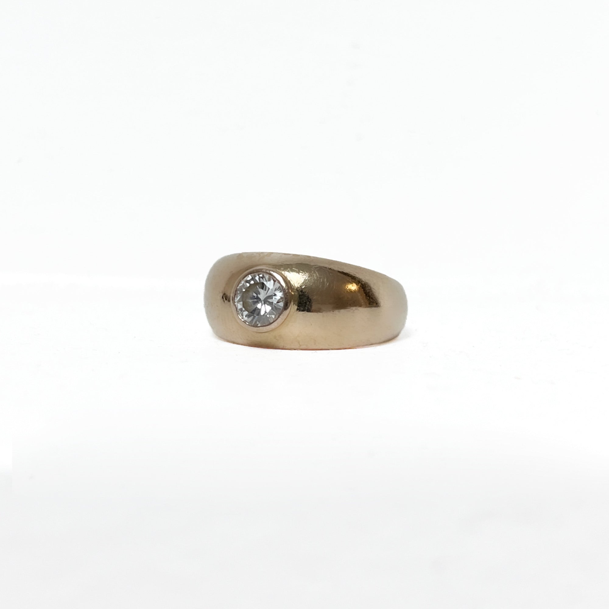 Profil d'une bague en or jaune 18 carats mettant en valeur son serti clos