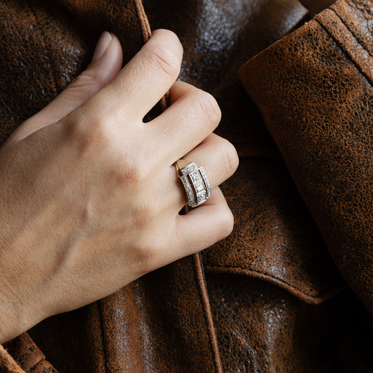 Bague moderniste des années 1950 en or blanc 18 carats et diamants, portée sur une main sur blouson en cuir.