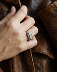 Bague moderniste des années 1950 en or blanc 18 carats et diamants, portée sur une main sur blouson en cuir.