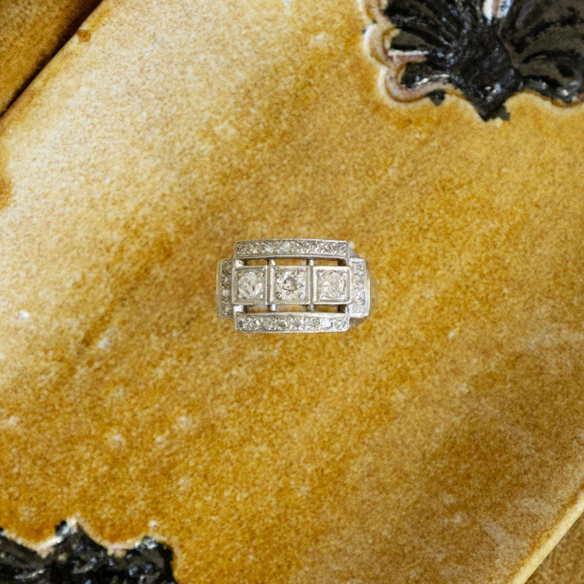Bague moderniste des années 1950 en or blanc 18 carats et diamants, présenté sur un fond jaune.