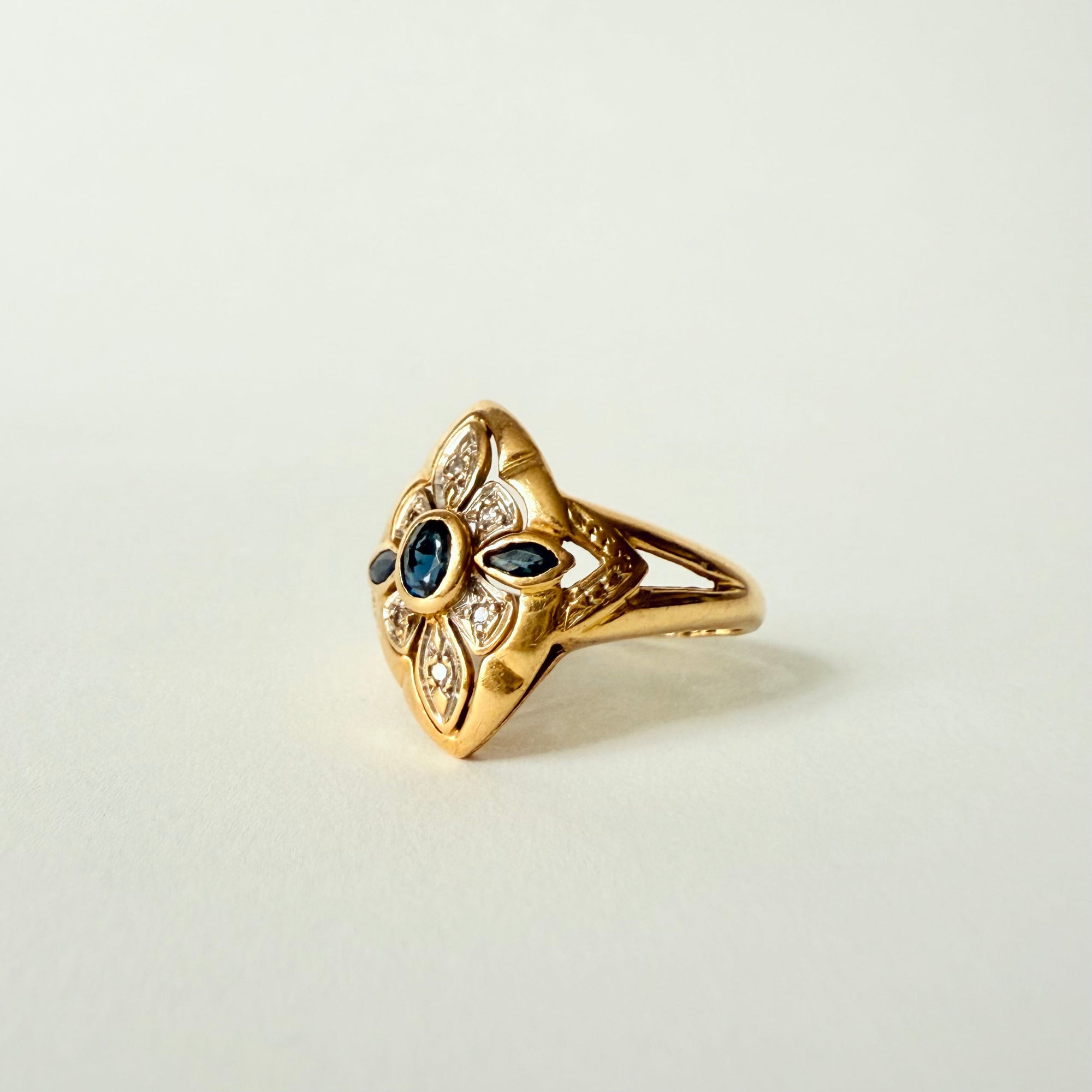 Bague navette ancienne en or jaune et or gris 18 carats, sertie de saphirs et diamants taille brillant – bijou vintage élégant et raffiné.