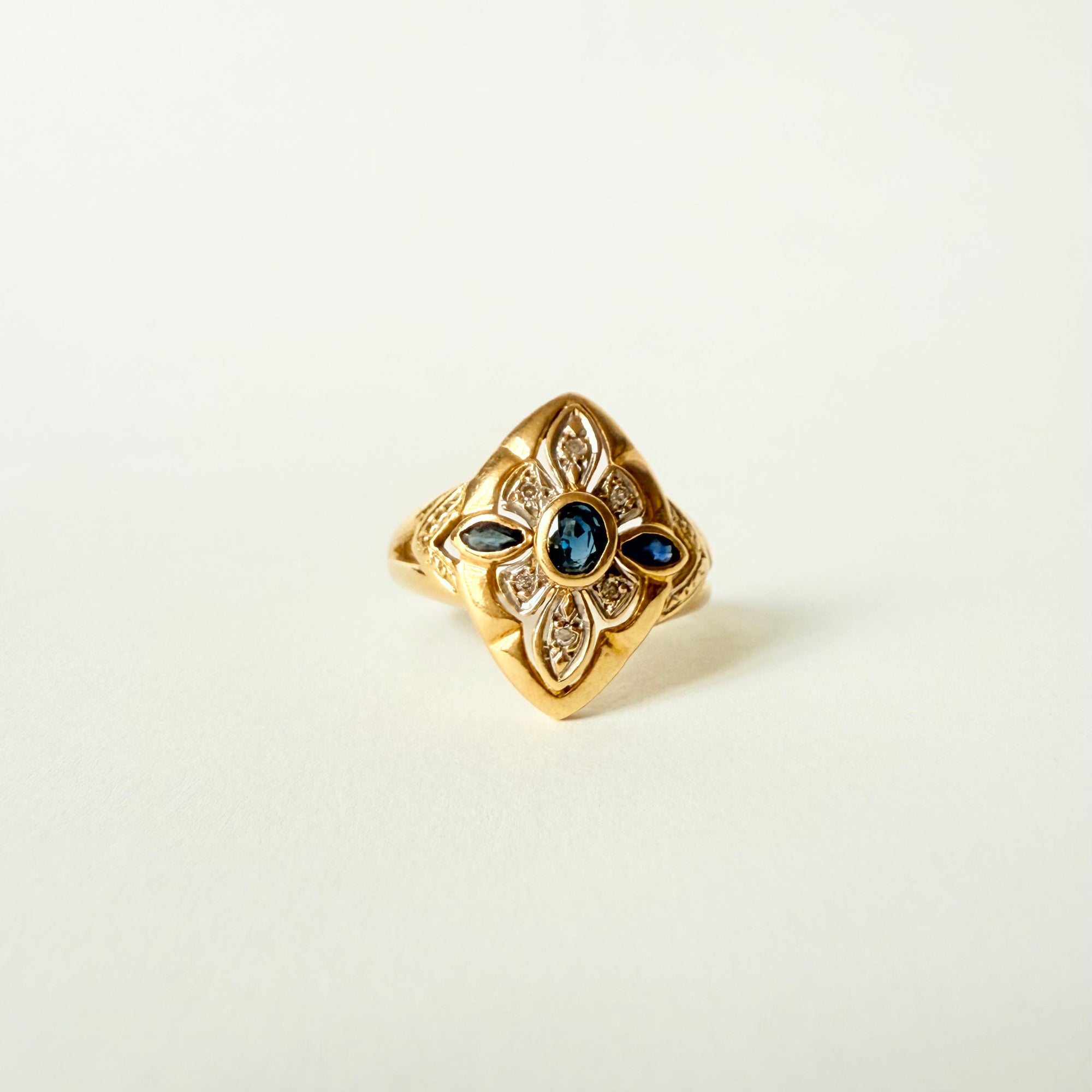 Bague navette ancienne en or jaune et or gris 18 carats, sertie de saphirs et diamants taille brillant – bijou vintage élégant et raffiné.