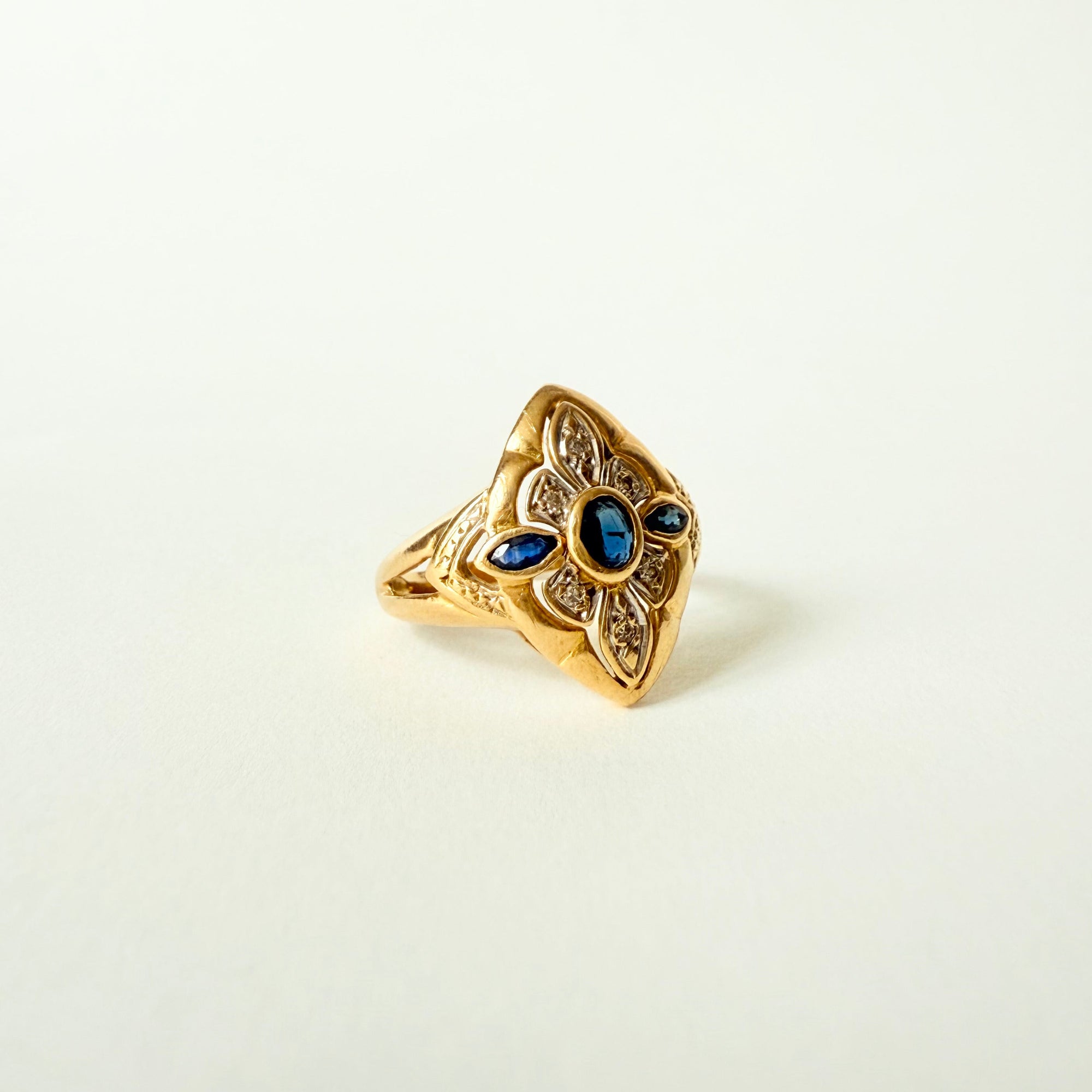 Bague navette ancienne en or jaune et or gris 18 carats, sertie de saphirs et diamants taille brillant – bijou vintage élégant et raffiné.