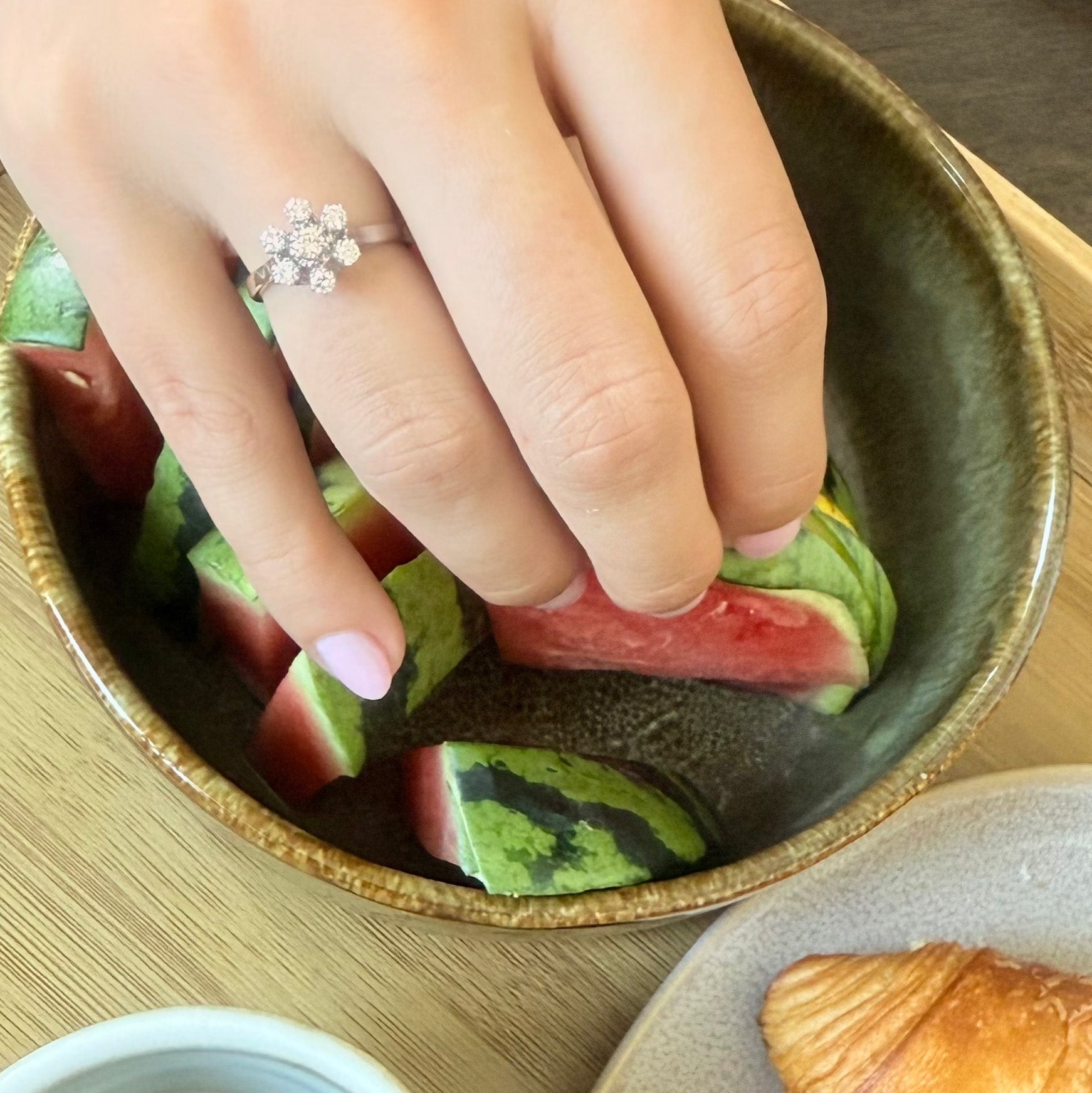 Bague en or gris 18 carats sertie de sept diamants taille brillant en serti griffe formant une fleur sur une monture ajourée, bijou raffiné et lumineux.