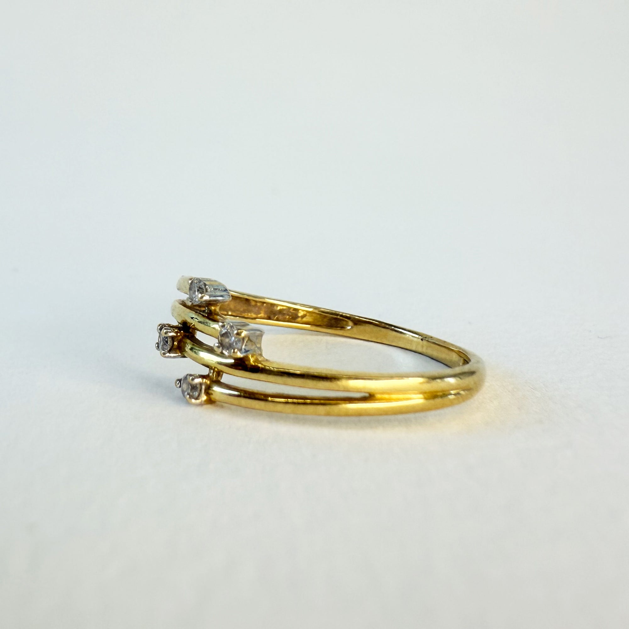 Bague en or jaune 18 carats ornée de quatre petits diamants, bijou fin et élégant aux lignes simples, parfait pour un port quotidien.