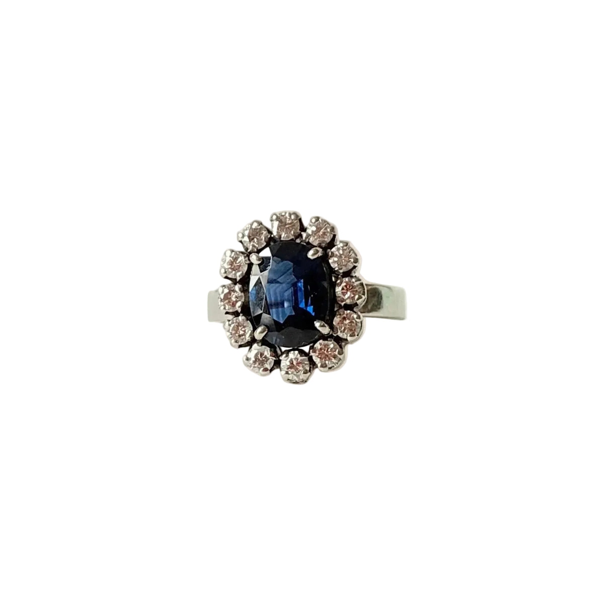 Bague marguerite en or blanc 18 carats sertie d'un saphir naturel ovale entouré de 12 diamants, vue de face.
