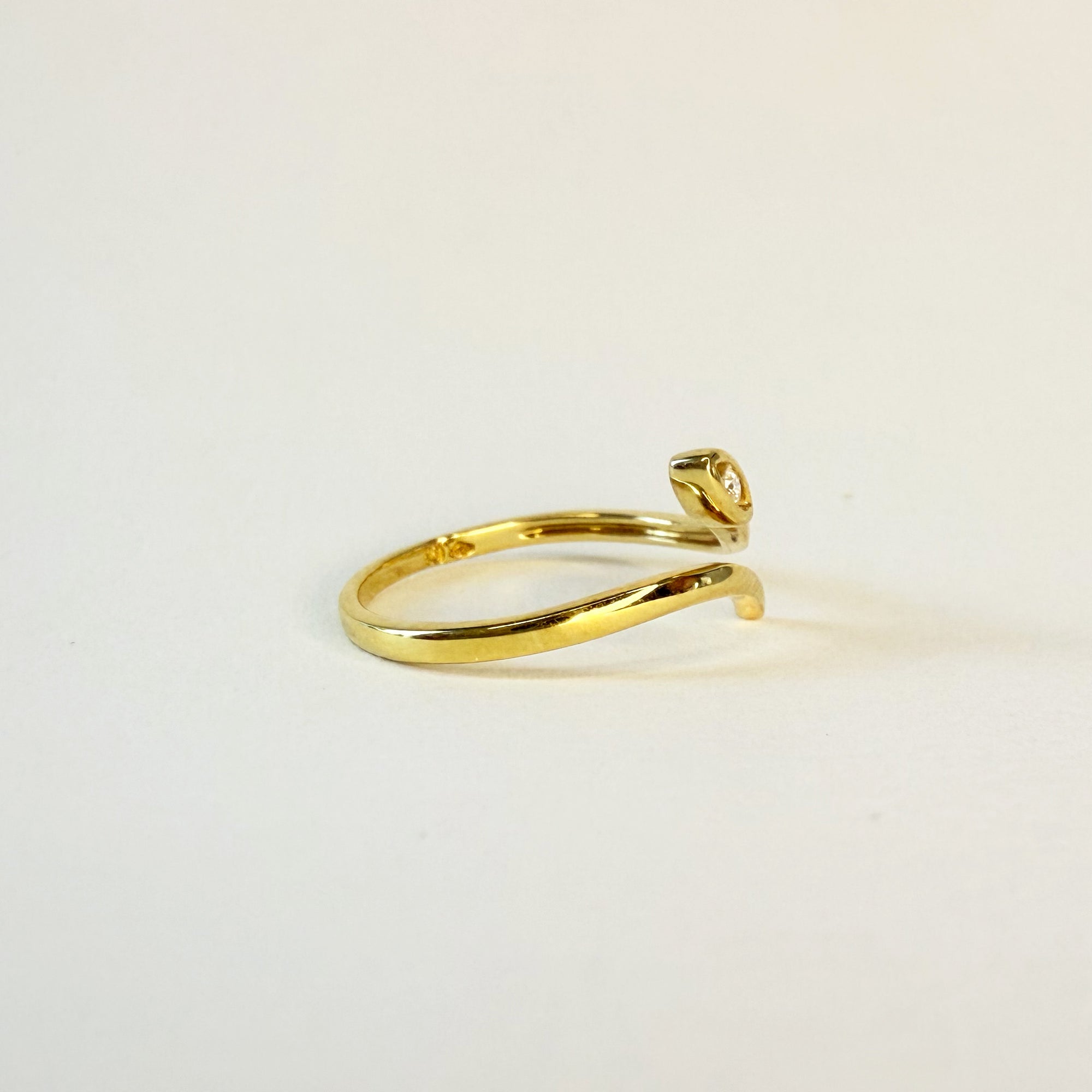 Vue de profil d’une bague serpent en or jaune 18 carats ornée d’un diamant