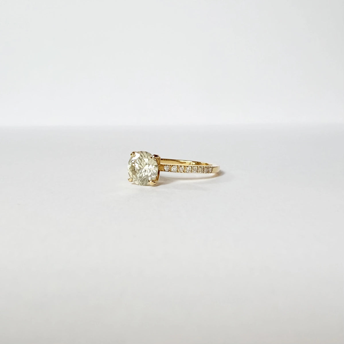Bague de fiançailles en or jaune ornée d'un important diamant de 1.5 carats sur une monture en or et diamants, vue de côté