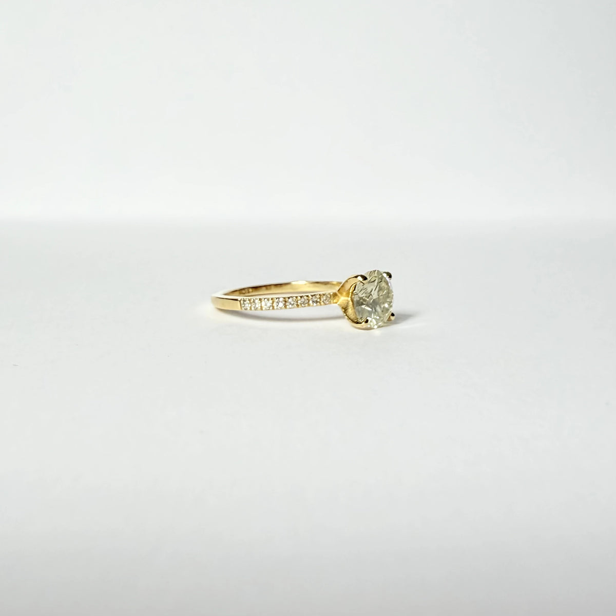 Bague de fiançailles en or jaune ornée d'un important diamant de 1.5 carats sur une monture en or et diamants