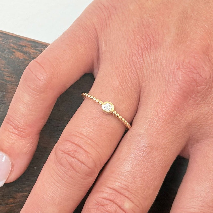 Bague de fiançailles solitaire en or jaune 18 carats sertie d’un diamant, symbole d’amour éternel et d’engagement.