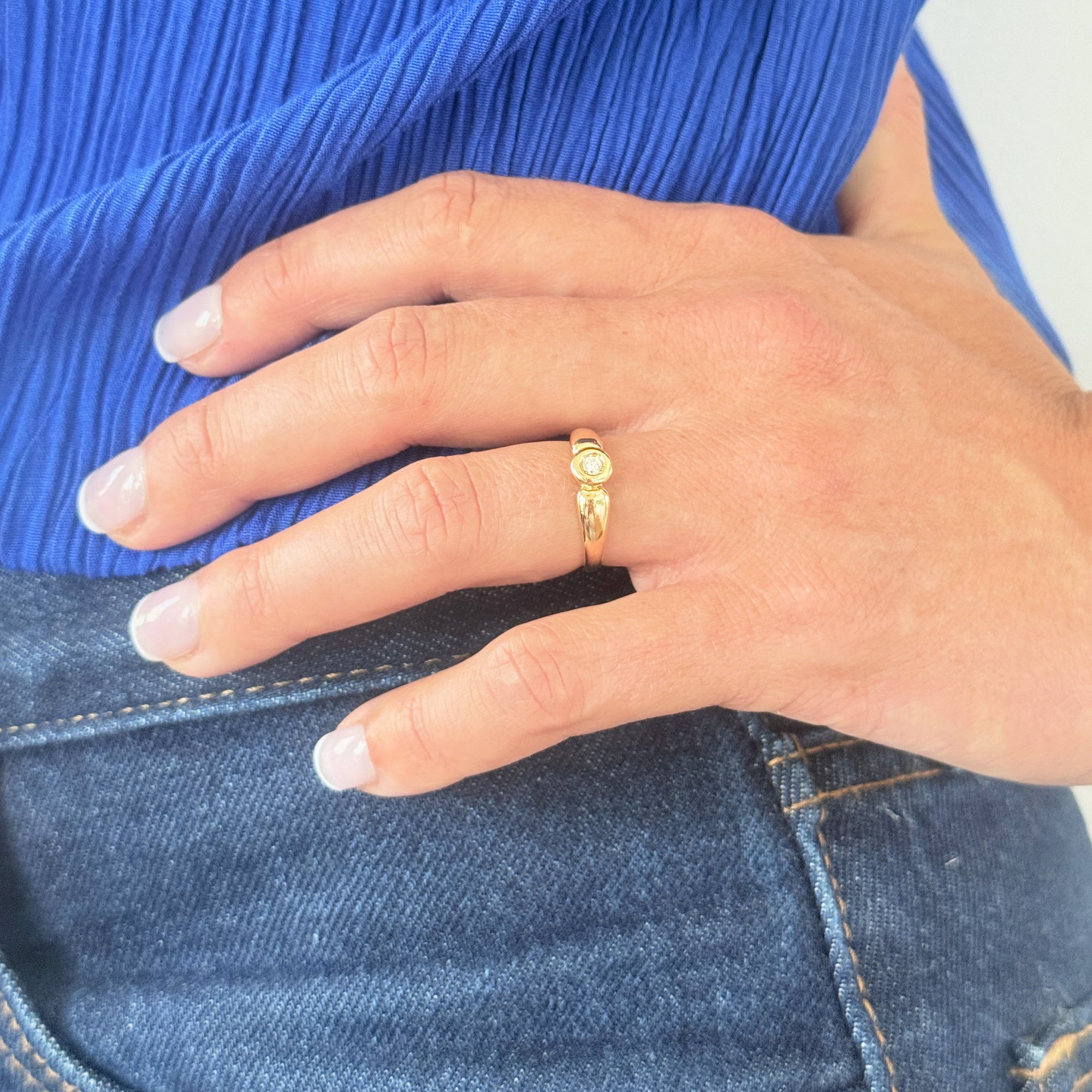 Bague solitaire en or jaune 18 carats sertie d’un diamant en serti clos d’environ 0,07 carat, bijou raffiné symbole d’amour éternel et d’engagement.