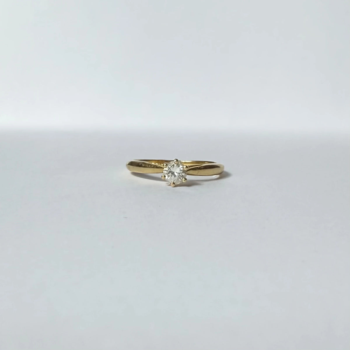 Bague solitaire en or jaune 18 carats ornée d'un diamant de 0,2 carats, vue de face. 