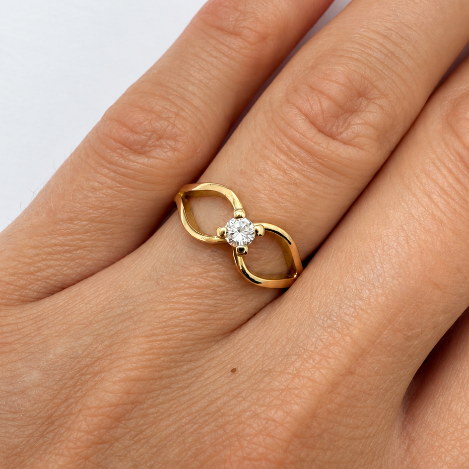 SOlitaire en or jaune 18 carats orné d'un diamant sur une monture en volutes.