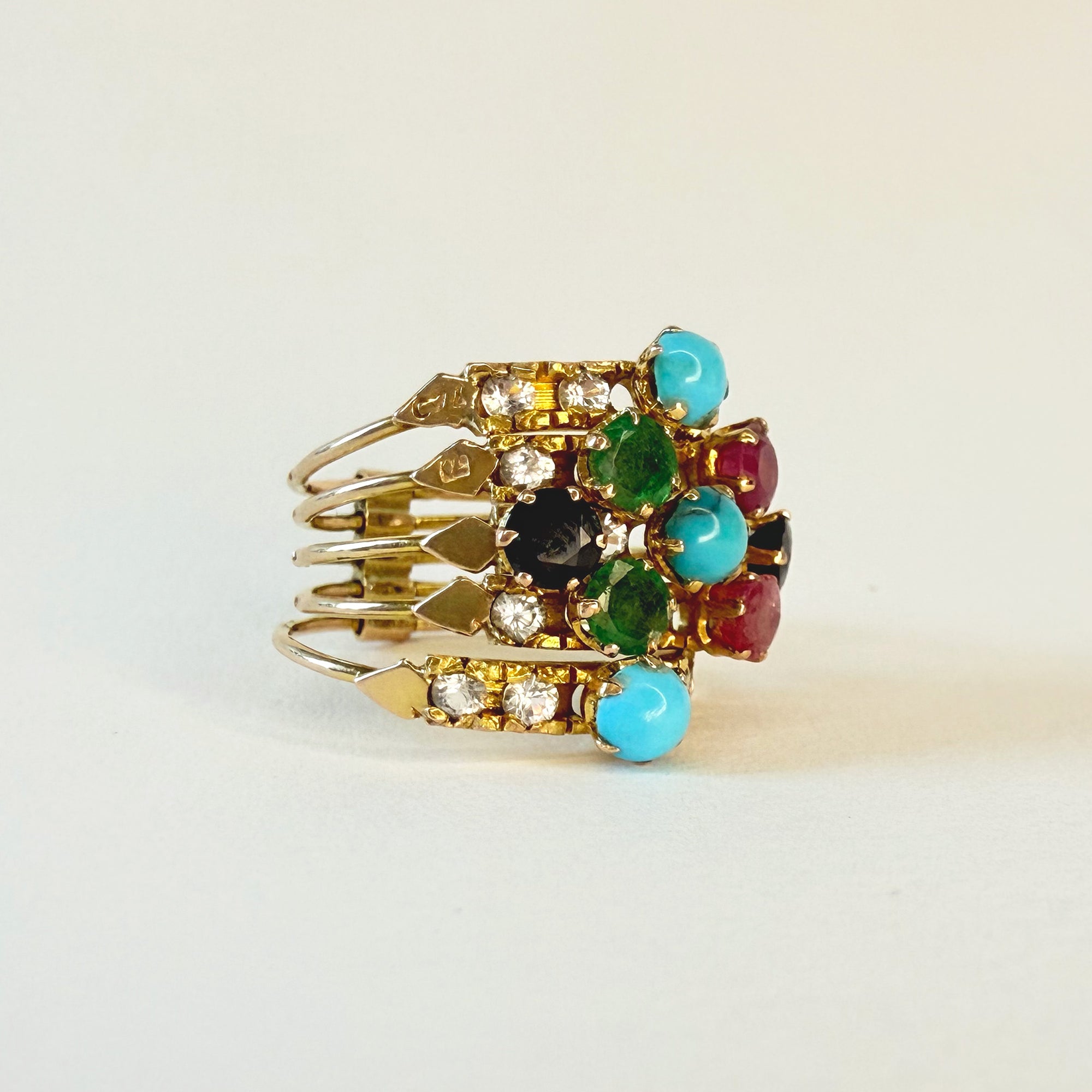 Vue de détail de la bague de harem en or et turquoises, rubis, émeraudes