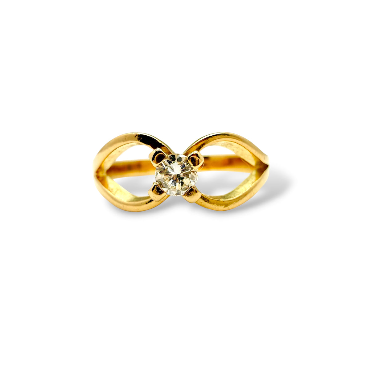 SOlitaire en or jaune 18 carats orné d'un diamant sur une monture en volutes.