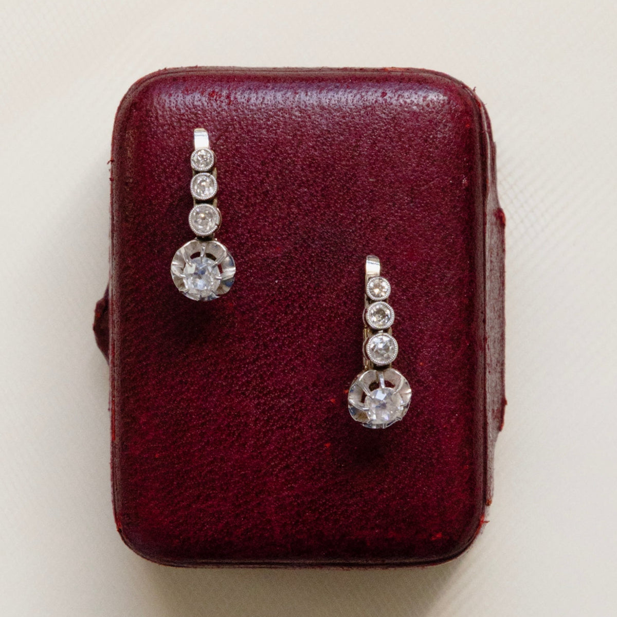Boucles d’oreilles dormeuses Art Déco en or blanc 18 carats serties de quatre diamants en chute.
