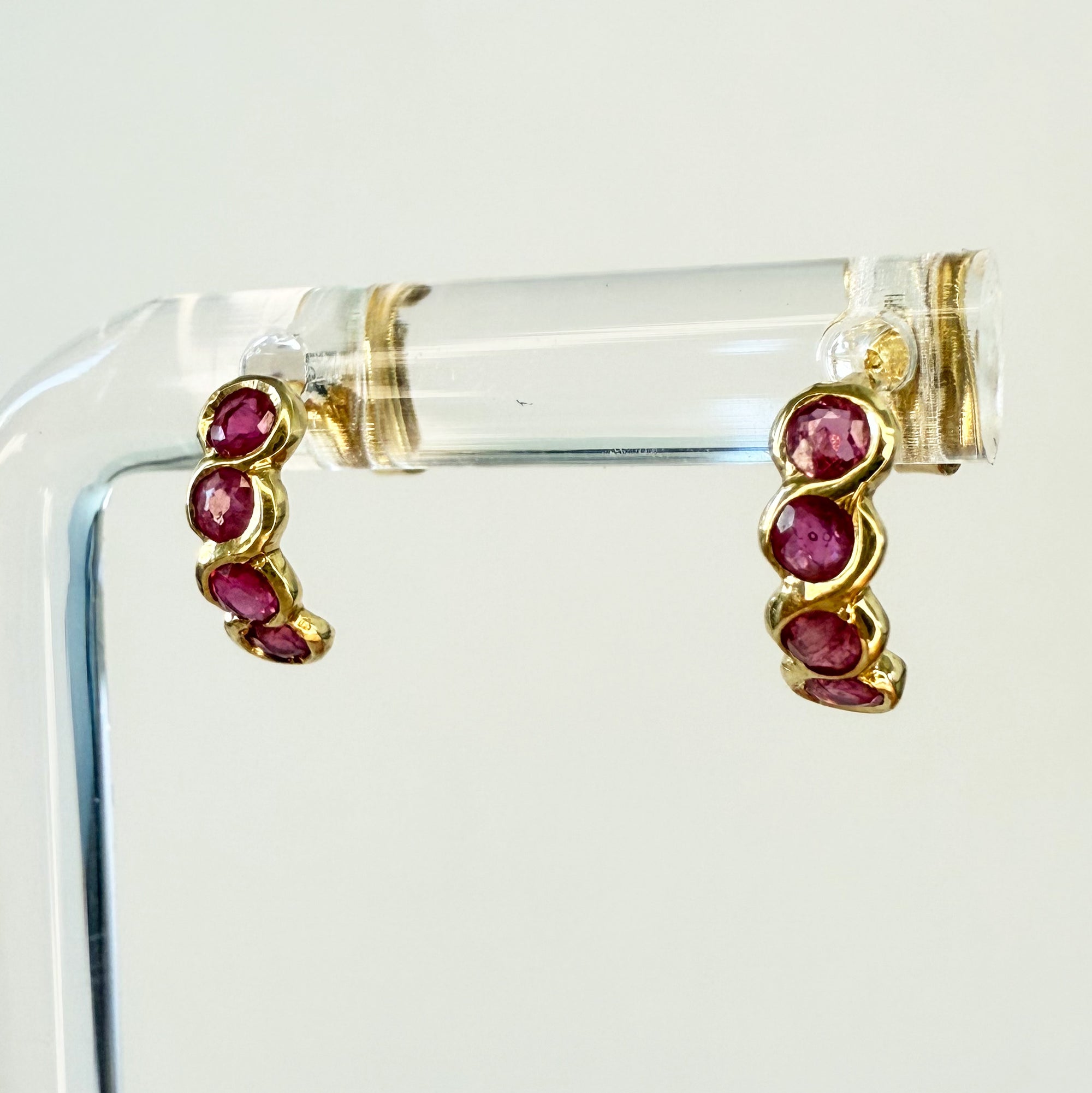 Paire de boucles d’oreilles en or jaune 18 carats ornées de quatre rubis ronds en serti clos, bijoux élégants et colorés.