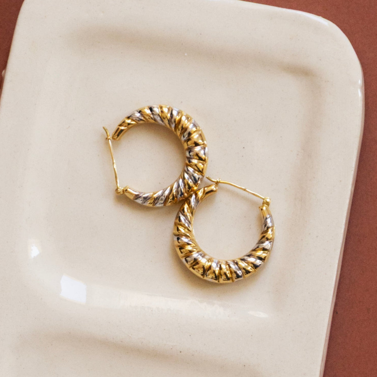 Boucles d'oreilles créoles en or de style années 1970-80, design vintage, vu de haut.