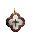Pendentif croix en or et nacre avec design moderne, fabriqué par Maison Labrune, posé sur un fond en bois naturel.