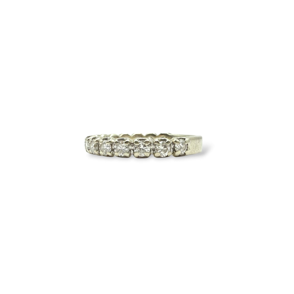 Détail du serti griffes d’une demi-alliance en or blanc 18 carats, mettant en valeur une rangée de diamants taille moderne.