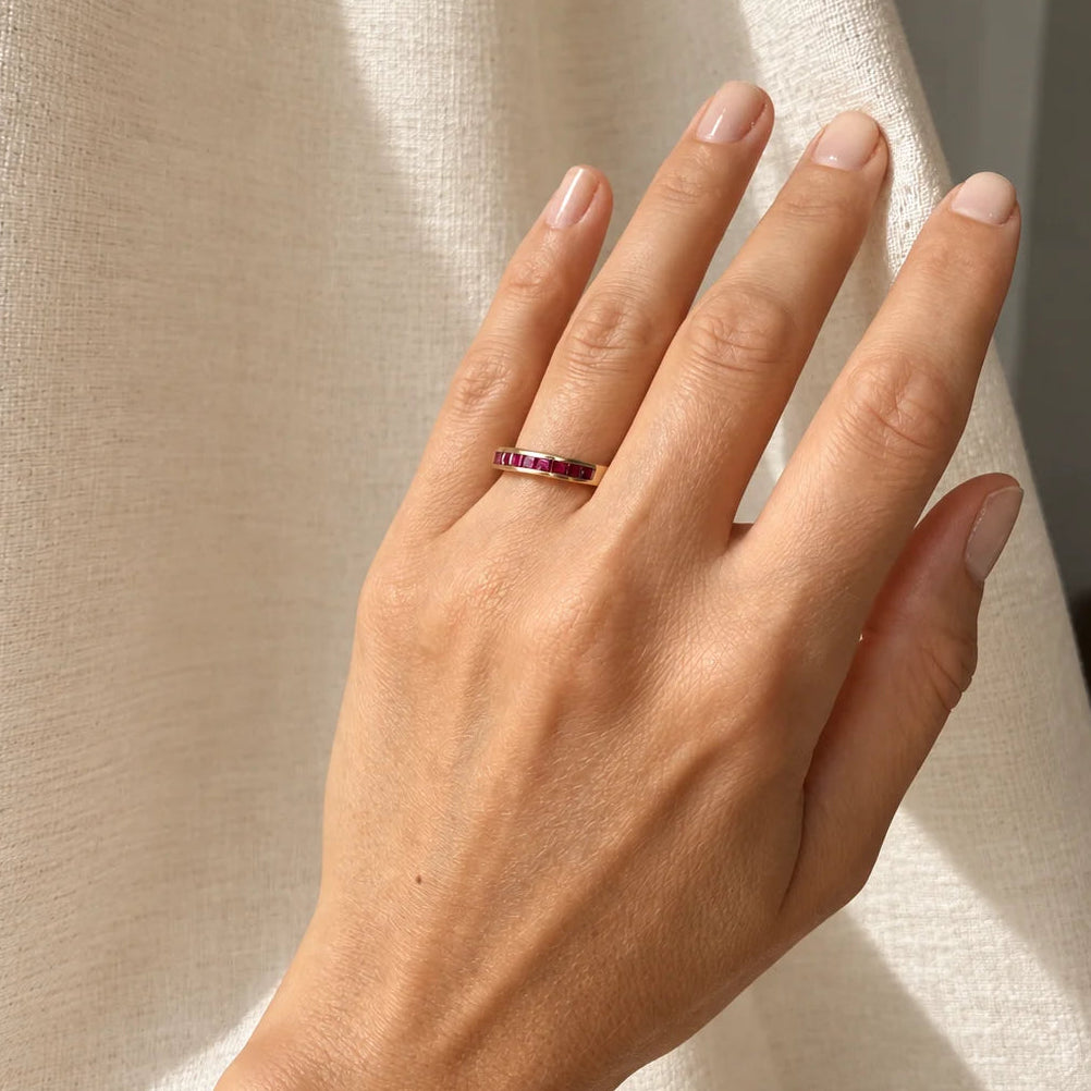bague vintage demi-alliance en or jaune 18 carats ornée de rubis calibrés.