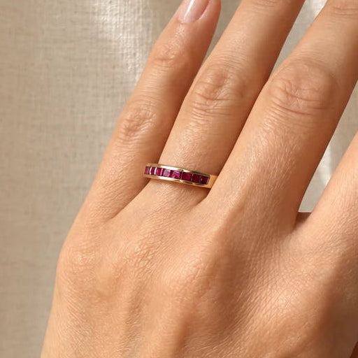 bague vintage demi-alliance en or jaune 18 carats ornée de rubis calibrés.